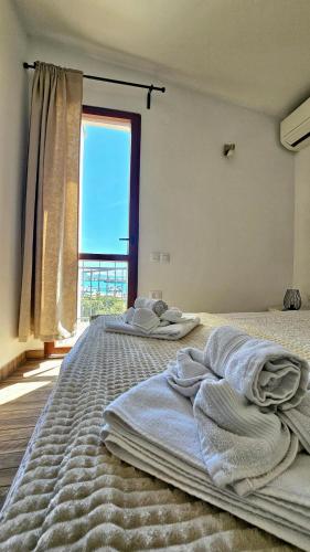 two beds in a room with a large window at Apartment Memories II in Baška