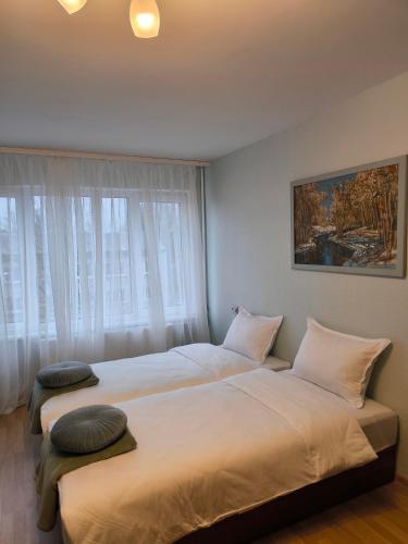 two beds sitting next to each other in a bedroom at Central Point Apartments in Rēzekne