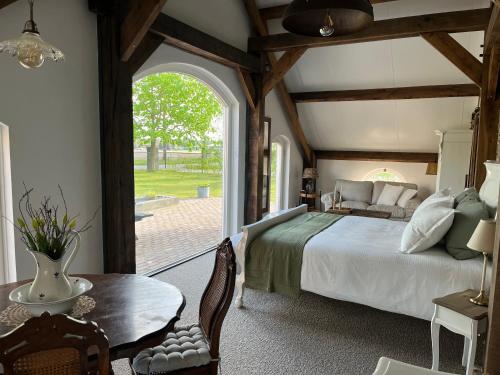 a bedroom with a bed and a large window at B&B De Cootjes in Ossendrecht
