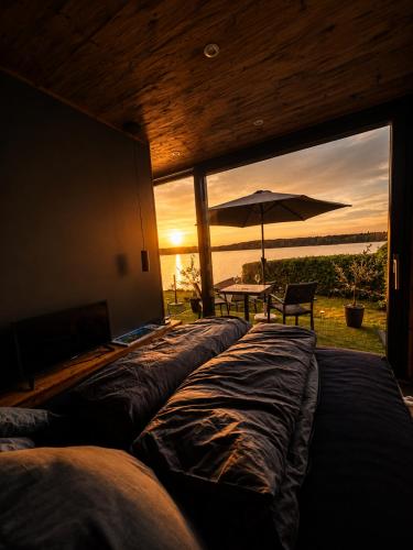 a room with a large window with a table and an umbrella at Seechalet Kranich in Roding
