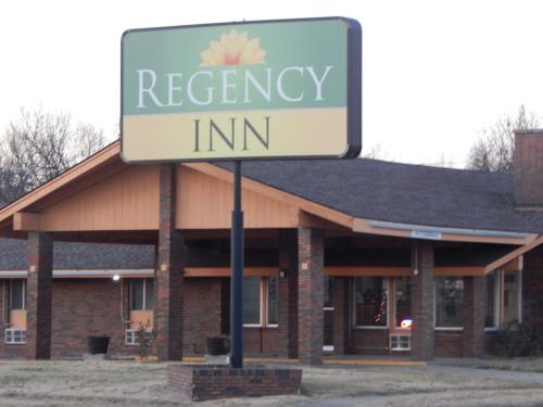 a sign that reads recovery inn in front of a building at Regency Inn Iola in Iola