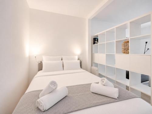 a white bedroom with a bed with towels on it at Le Ravissant - plage et casino à 2 min, Houlgate in Houlgate