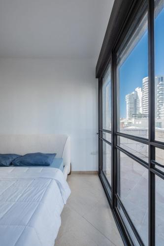 a bedroom with a bed and a large window at וילה הריביירה in Netanya