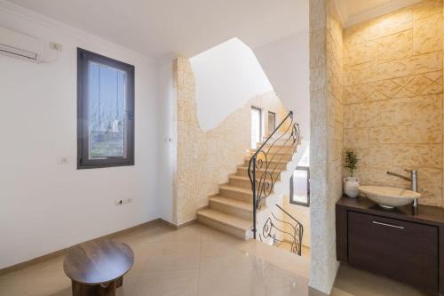 a bathroom with a staircase and a sink and a stair railing at וילה הריביירה in Netanya