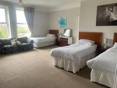 a hotel room with two beds and a couch at Highland Moors in Llandrindod Wells