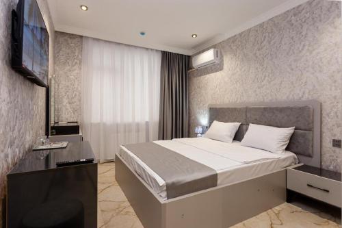a hotel room with a bed and a television at Şimal Hotel in Quba