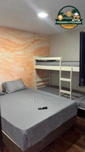 a bedroom with two bunk beds and a television at Hospedagem e pizzaria florestinha in Búzios
