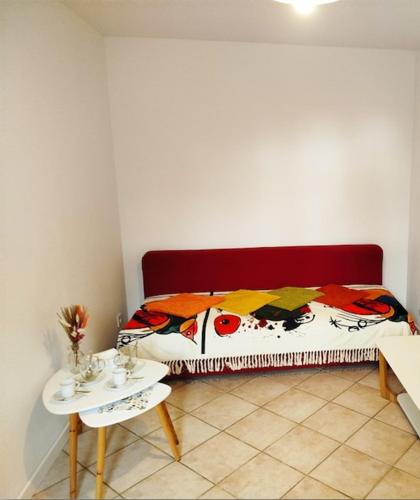 a room with a bed with a table and a table with a bedspread at Gîte Mézilles location sem-we in Mézilles