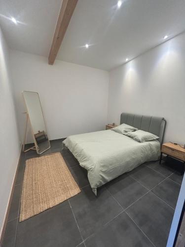 a bedroom with a bed in a white room at Petite maison Dépendance SOUSTONS in Soustons