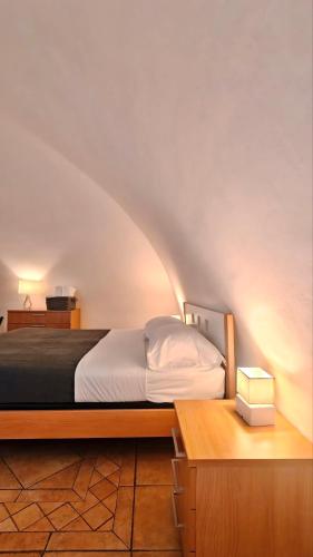 a bedroom with a bed and a desk with a night stand at Giù nei Sassi in Matera