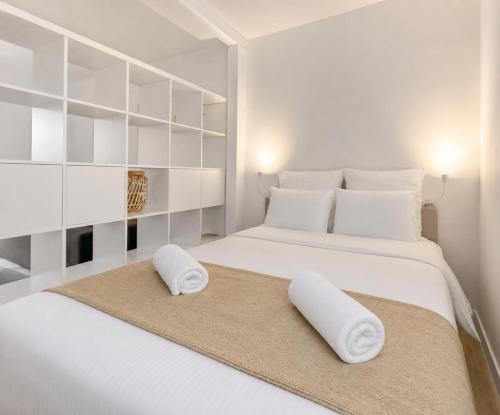 a white bedroom with two pillows on a bed at Le Charmant - plage & restaurants à pied, Houlgate in Houlgate