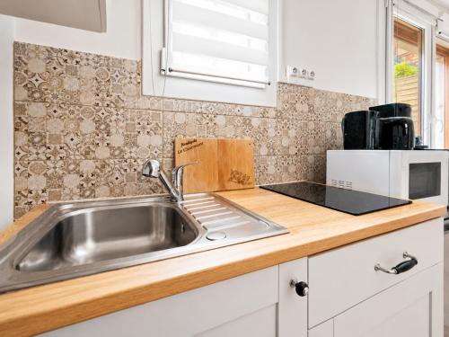 a kitchen with a sink and a microwave at Le Charmant - plage & restaurants à pied, Houlgate in Houlgate