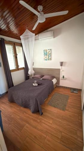 a bedroom with two beds and a ceiling fan at Pépite Anses in Les Anses-dʼArlets