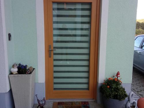 a wooden door on a house with a plant at Wohlfühlwohnung in Rappottenstein