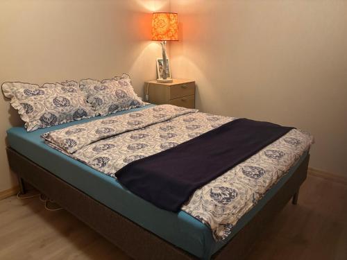 ein Bett in einem Schlafzimmer mit einer Lampe auf einem Tisch in der Unterkunft Sandve in Sandve