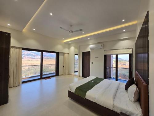 a bedroom with a large bed and large windows at Kamal in Kārli