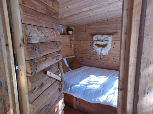 a small room with a bed in a wooden cabin at Brescou Lodges in Murviel