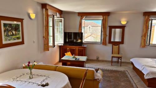 a living room with a couch and a tv at Apartments Residence Astoria in Rab