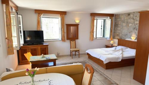 a hotel room with a bed and a tv at Apartments Residence Astoria in Rab
