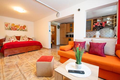 a living room with orange furniture and a red couch at Apartments Anita in Pula