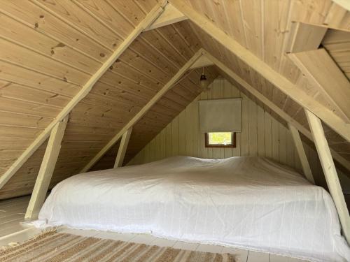 a bed in the attic of a wooden house at Hus Sinnermåla in Högsby