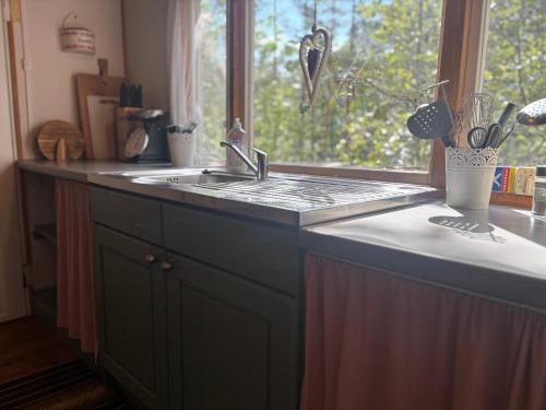 a kitchen counter with a sink and a window at Hus Sinnermåla in Högsby