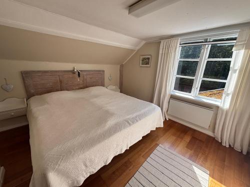 a bedroom with a white bed and a window at Hus Bokhultet in Ruda