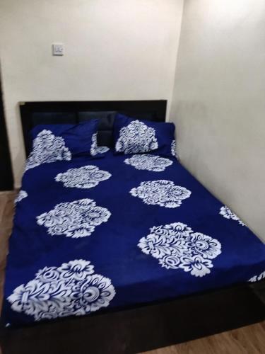 a bed with a blue comforter with white clouds on it at Bec property in Ikorodu