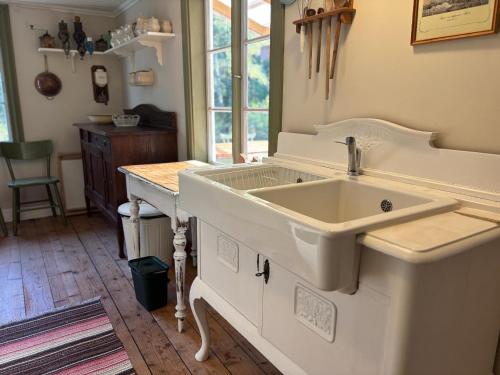 a white sink in a kitchen with a counter at Hus Blommekulla in Högsby
