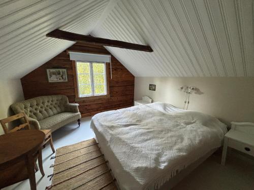 a bedroom with a bed and a couch in a attic at Hus Blommekulla in Högsby