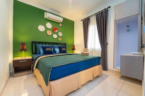 a bedroom with a bed and a green wall at Roemah Noni Baciro By ARBA in Demangan