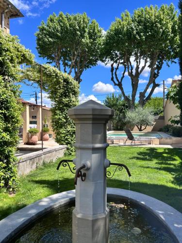 a water fountain in the middle of a yard at Les Tilleuls in Cavaillon