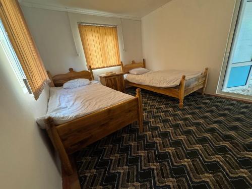 a room with two beds and a window at Sharsharai Haftkul in Panjakent