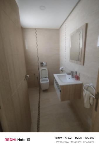 a bathroom with a white toilet and a sink at hedia a monastir in Monastir