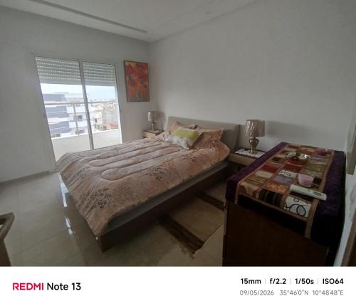a bedroom with a large bed and a window at hedia a monastir in Monastir