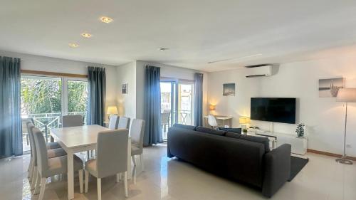 a living room with a table and a couch and a dining room at Garden Hill M - Shared Pool - 6 Guests - Albufeira in Albufeira