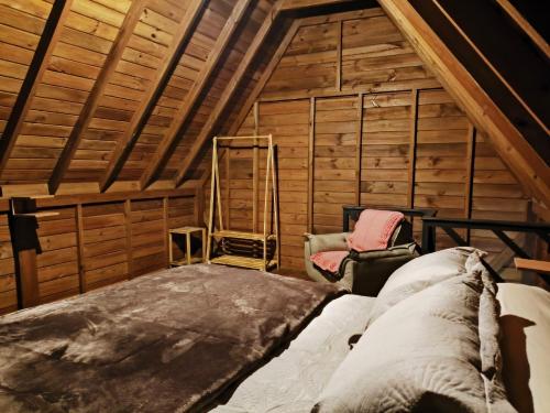an attic room with a bed and a ladder at Chalé na Vila Do Sossego in Alfredo Wagner