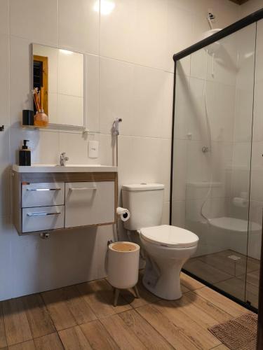 a bathroom with a toilet and a sink and a shower at Chalé na Vila Do Sossego in Alfredo Wagner