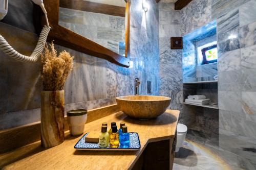 a bathroom with a bowl sink and bottles on a counter at Tulip Cave Suites in Göreme