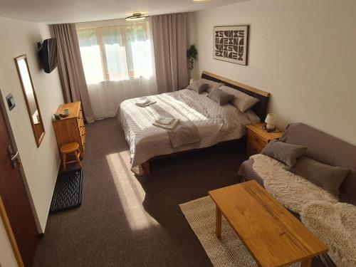 a hotel room with a bed and a couch at Nevesta hôľ pod Chopkom in Bystrá