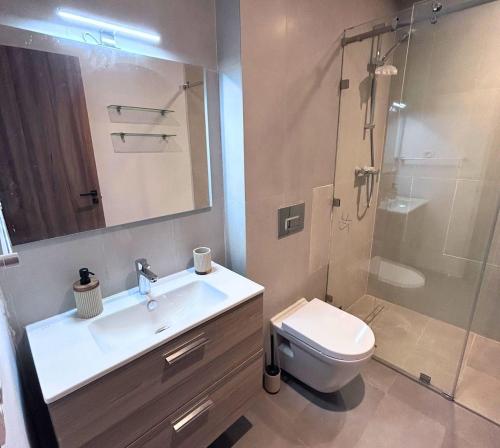 a bathroom with a sink and a toilet and a shower at Charmant studio, piscine proche mer in Aïn Harrouda