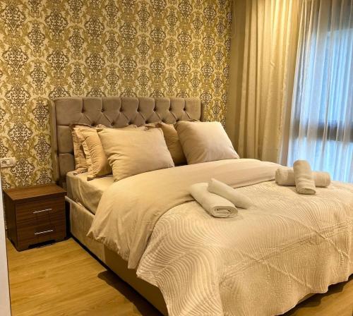 a bed with two pillows on it in a bedroom at Charmant studio, piscine proche mer in Aïn Harrouda