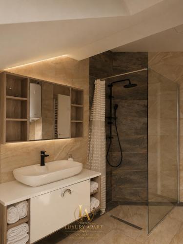 a bathroom with a sink and a shower at Luxury Apartments in Brčko