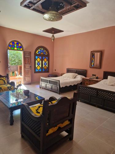 a room with two beds and a table and chairs at Casa Sofia in Meknès