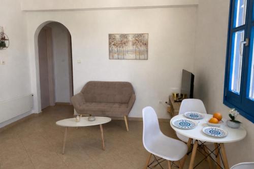 a living room with a couch and a table and chairs at Casa Ariadne in Náxos