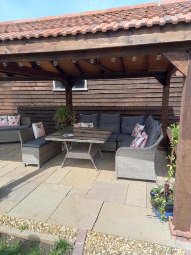 a wooden pavilion with a table and chairs on a patio at Rustic Retreat Guest Lodge in Littleport