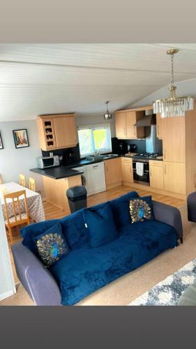 a living room with a blue couch and a kitchen at ocean view 15 in West Down