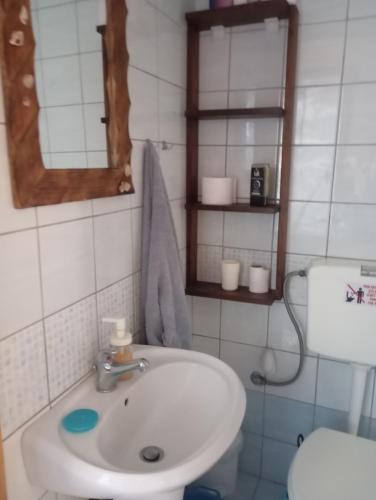 a bathroom with a sink and a toilet and a mirror at gialos house in Livadia