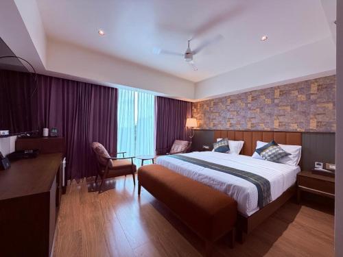 a hotel room with a bed and a desk at Hosta Inn Hotel and Resort in Edappāl