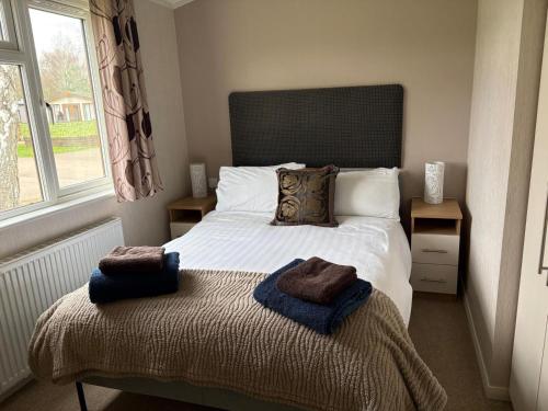 a bedroom with a bed with two towels on it at par 3 in Wisbech